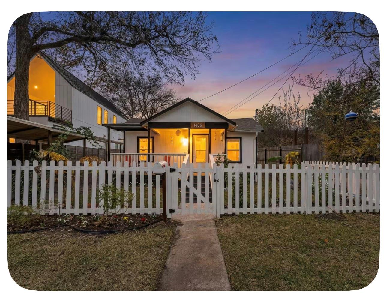 A charming picket fence frames the welcoming faca