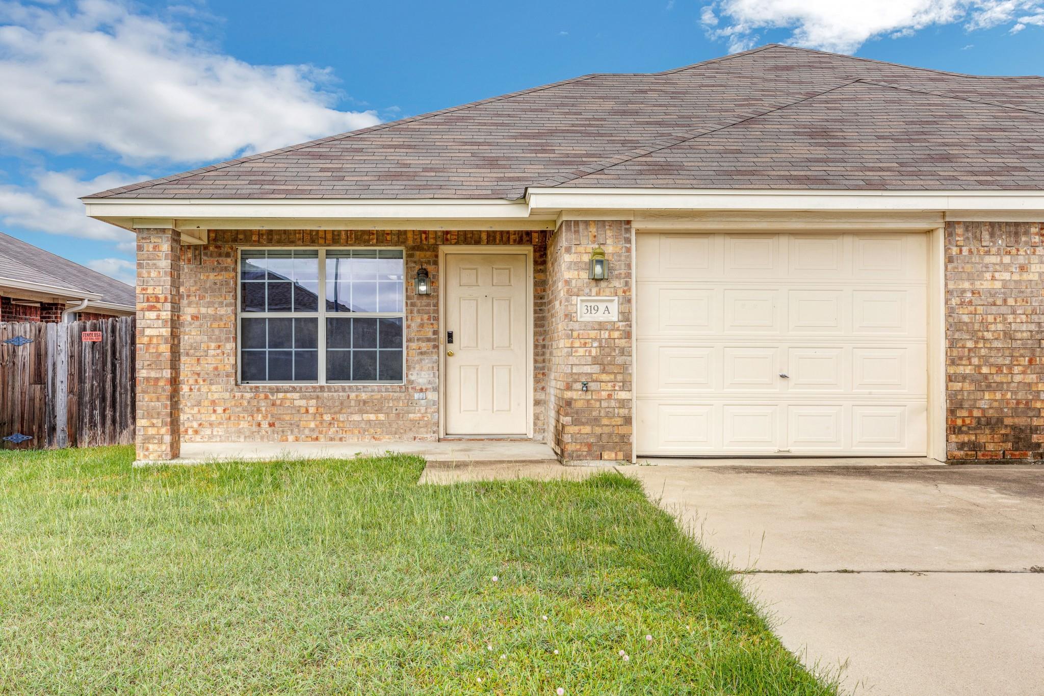 A classic brick facade with a neat lawn creates i