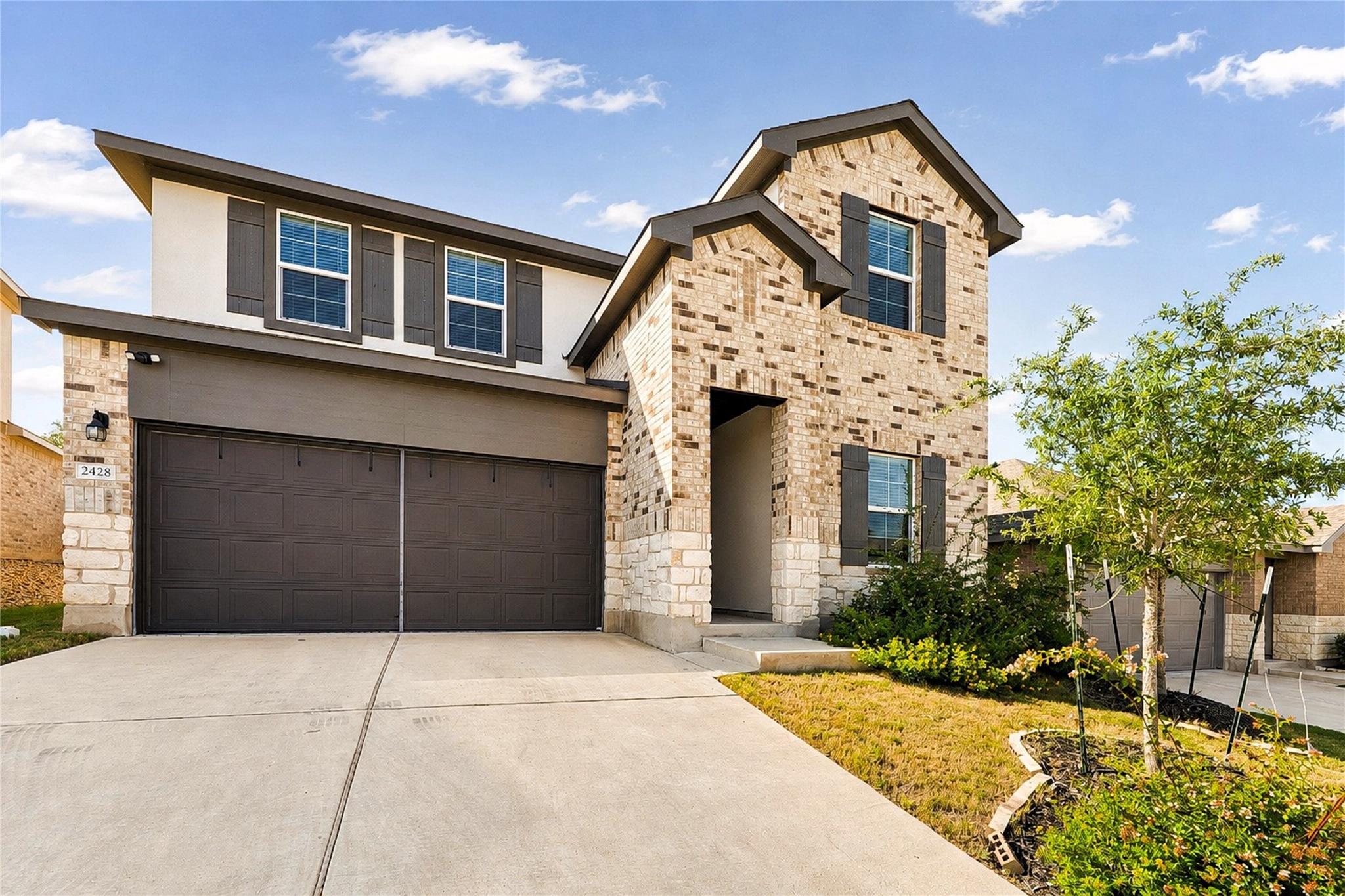 A well-maintained two-story home features a brick