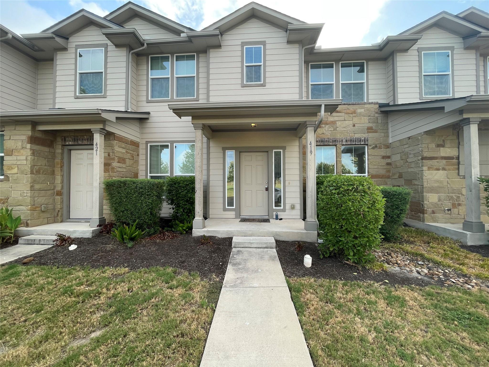 An inviting stone and siding entryway features a 