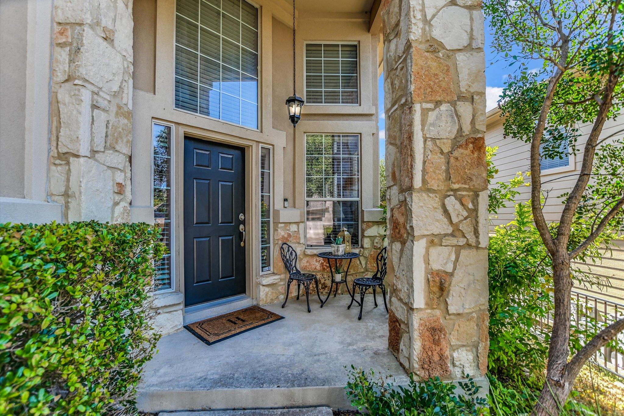 Natural stone columns frame a covered entry porch