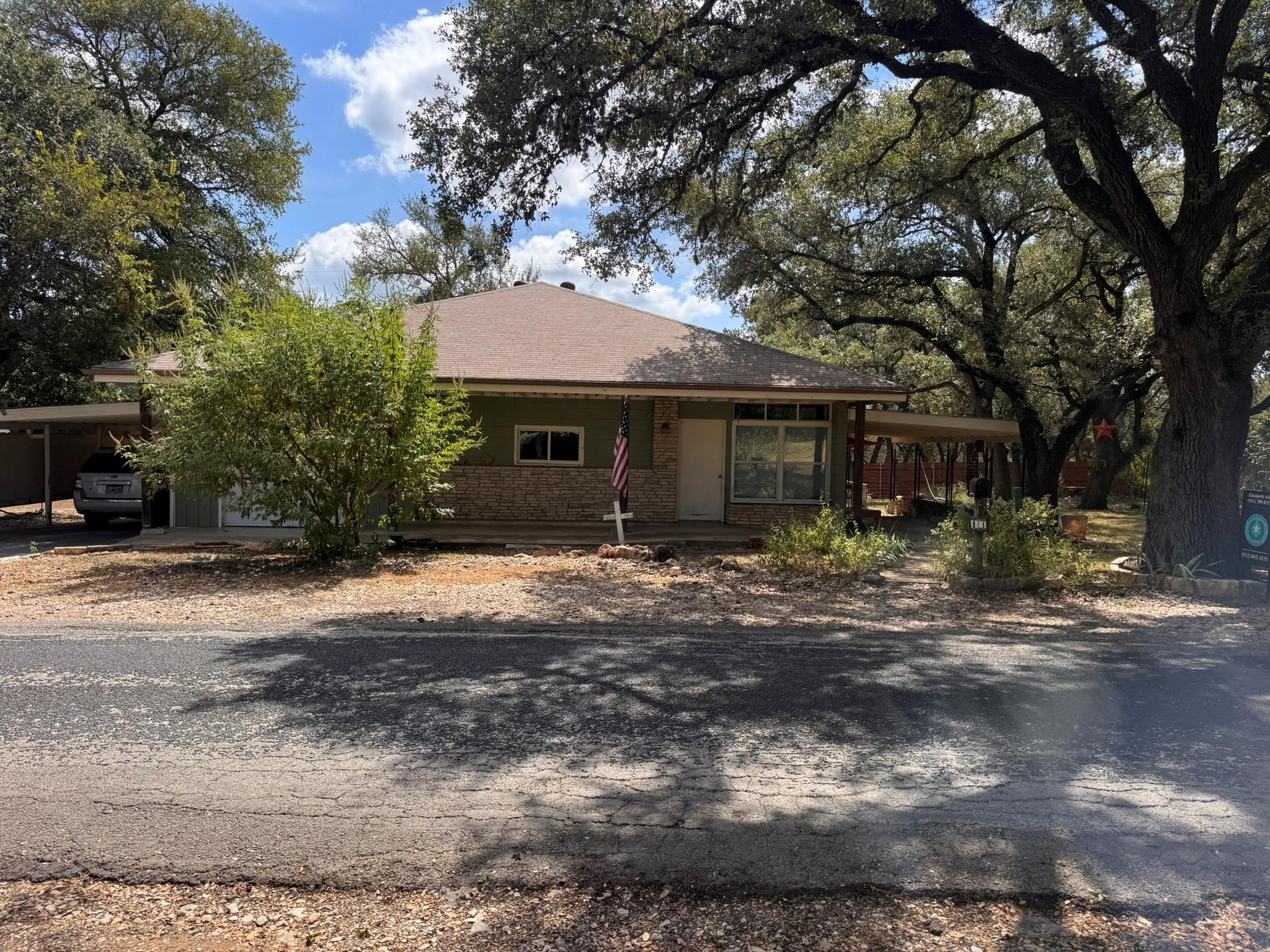 Mature oak trees shade a single-story home featur