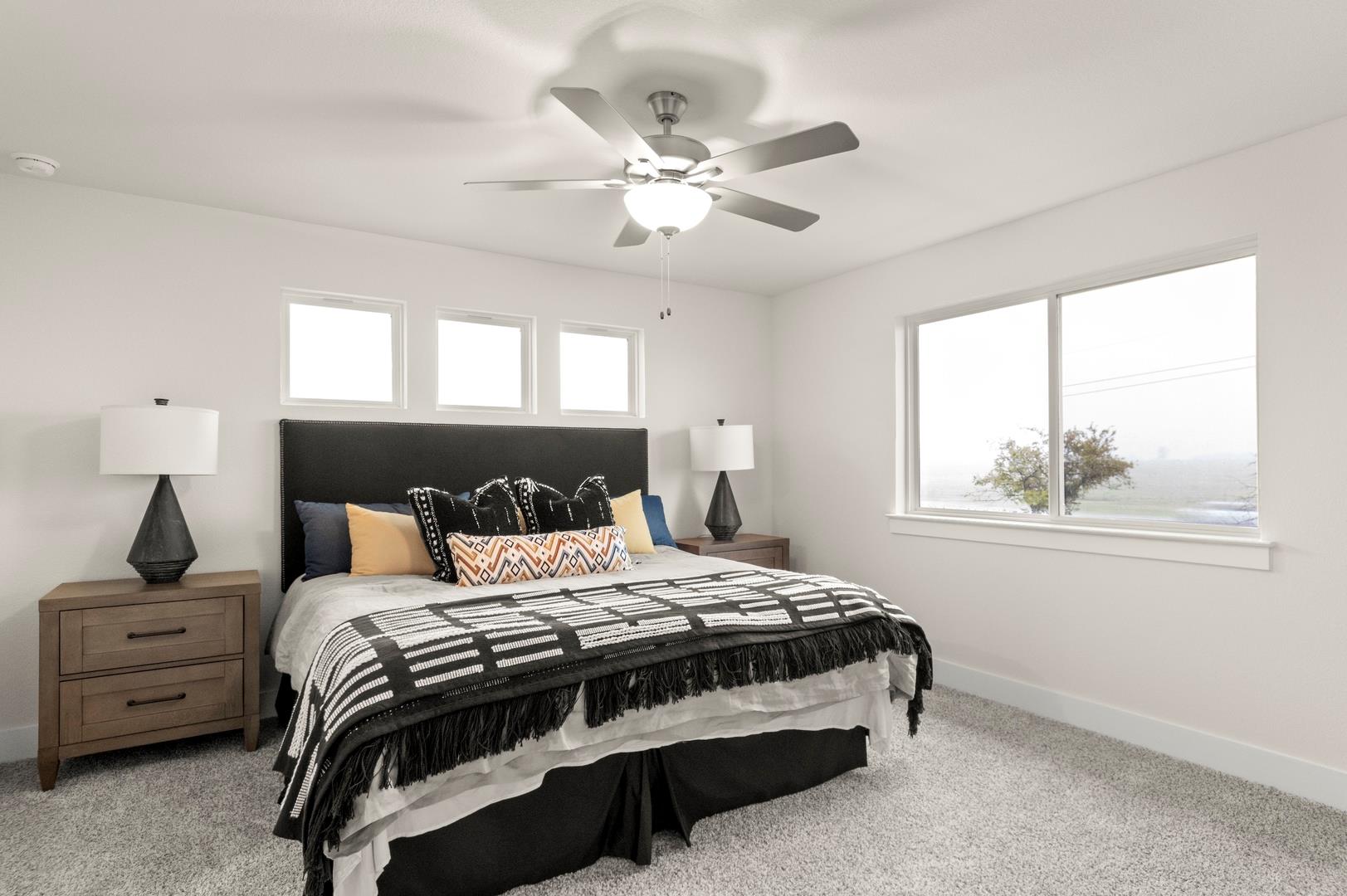 A comfortable bedroom features a ceiling fan, sof