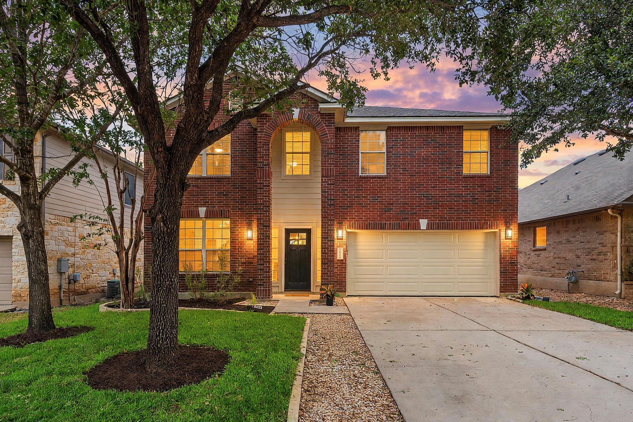 Mature trees shade a classic brick exterior compl