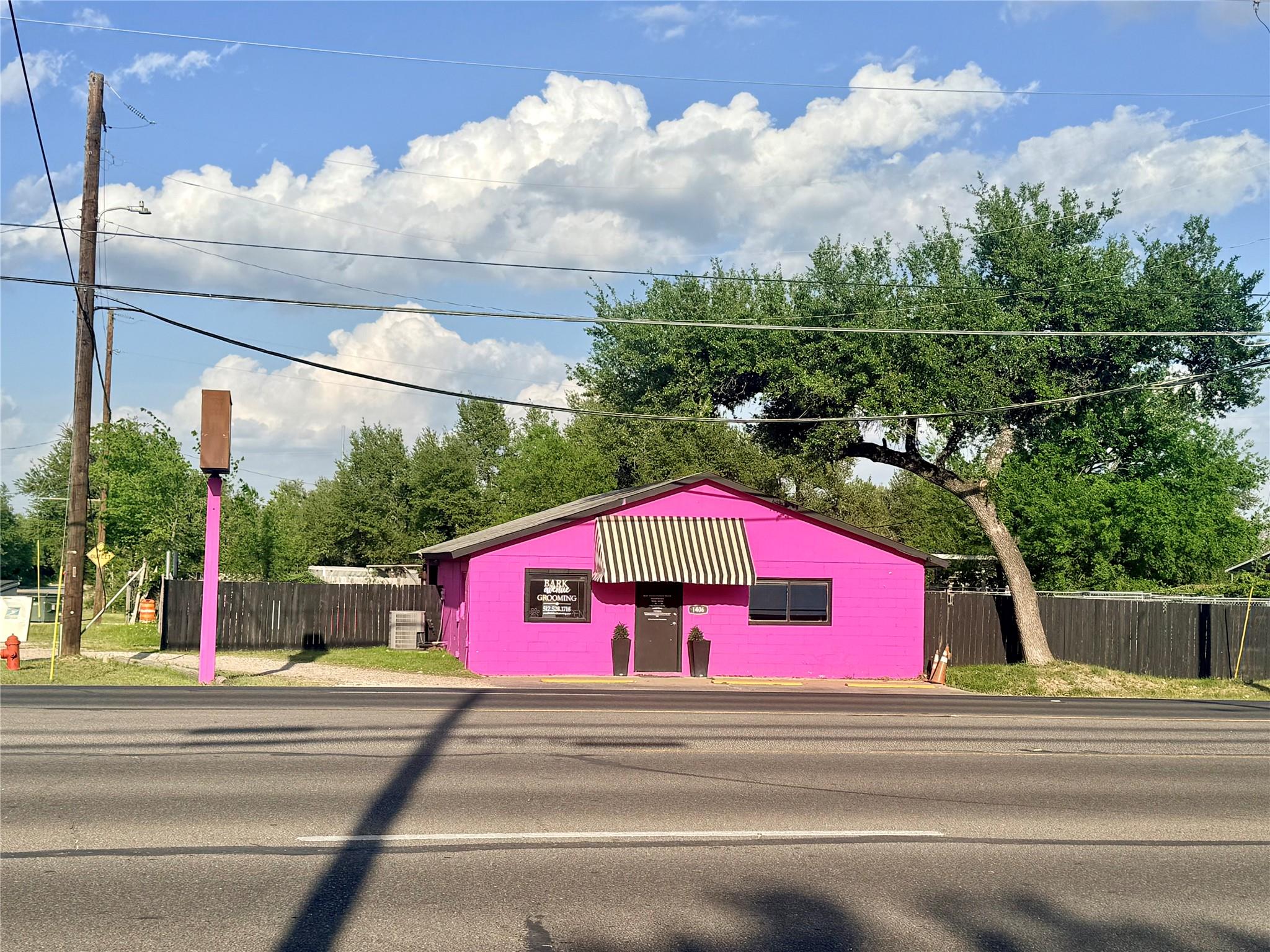 A vibrant magenta building with a striped awning 
