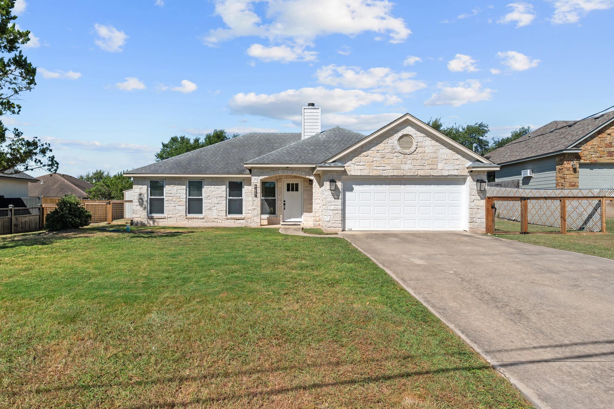 Limestone masonry and a wide concrete driveway de