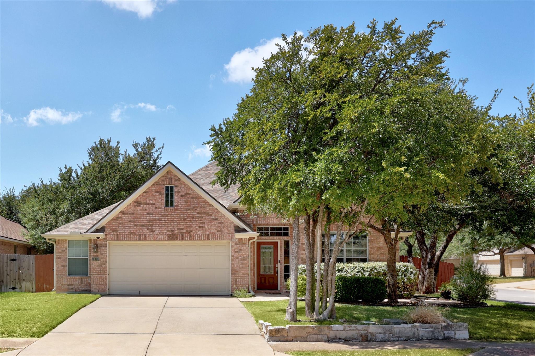 Mature trees frame a classic brick exterior with 