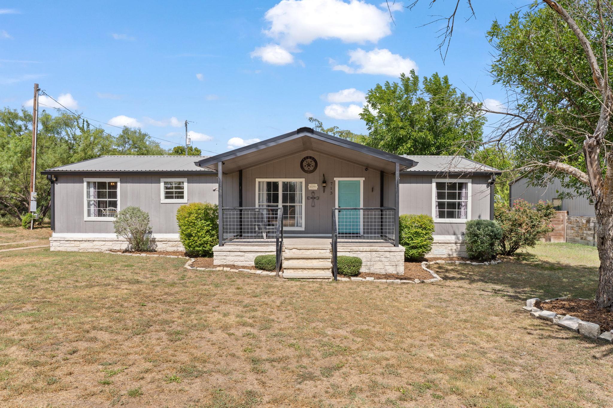 A welcoming facade offers a covered porch with me