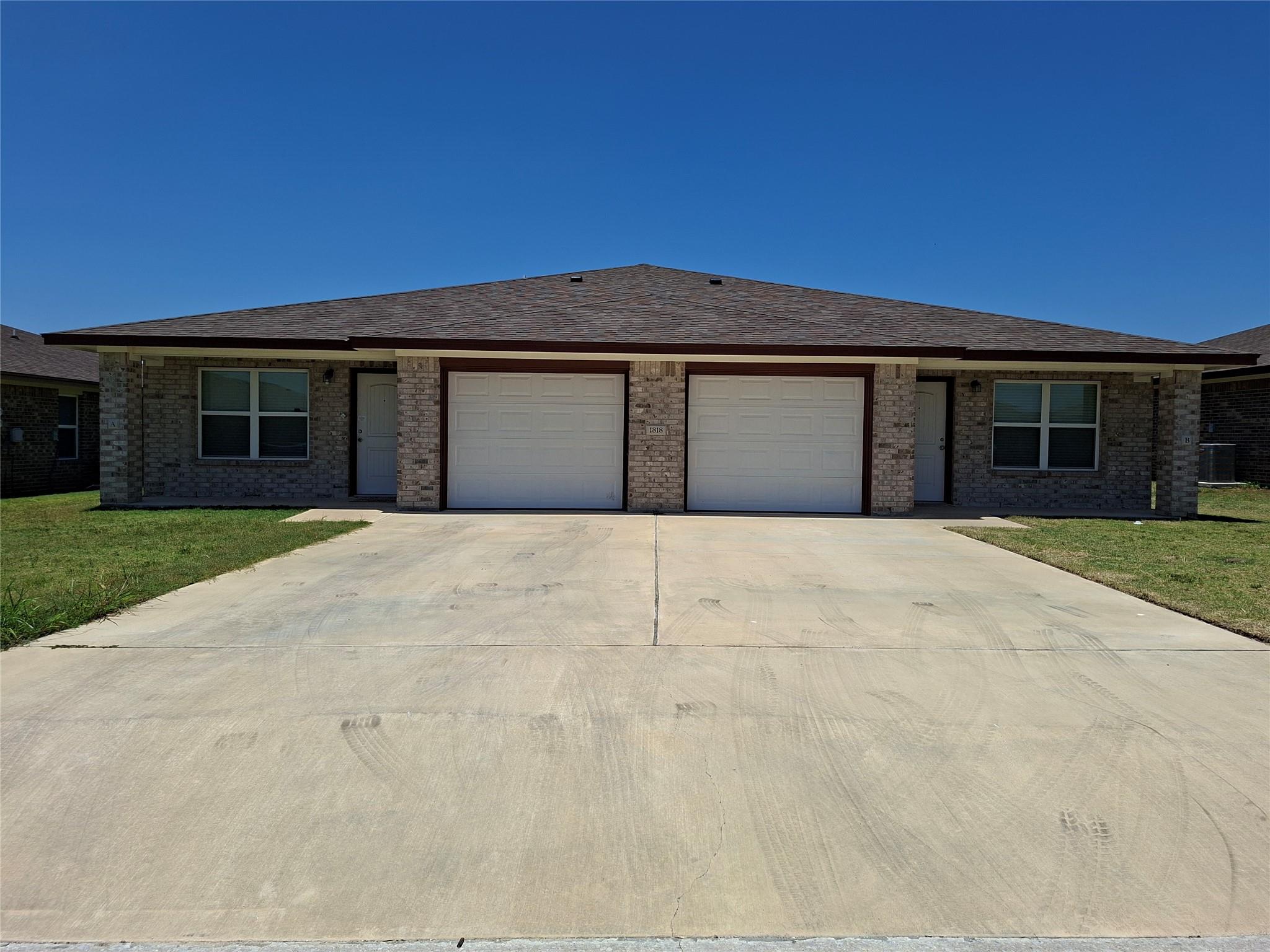 A well-maintained duplex with brick exterior and 