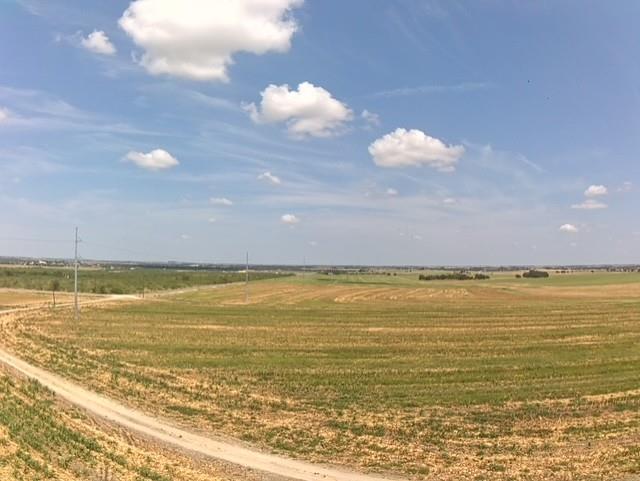 A vast expanse of fertile land unfolds under a wi