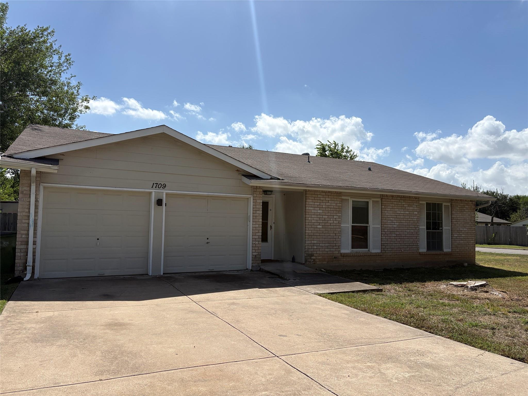 Classic brick accents and a spacious concrete dri