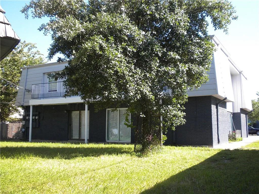 Rear view of property featuring brick siding, a l