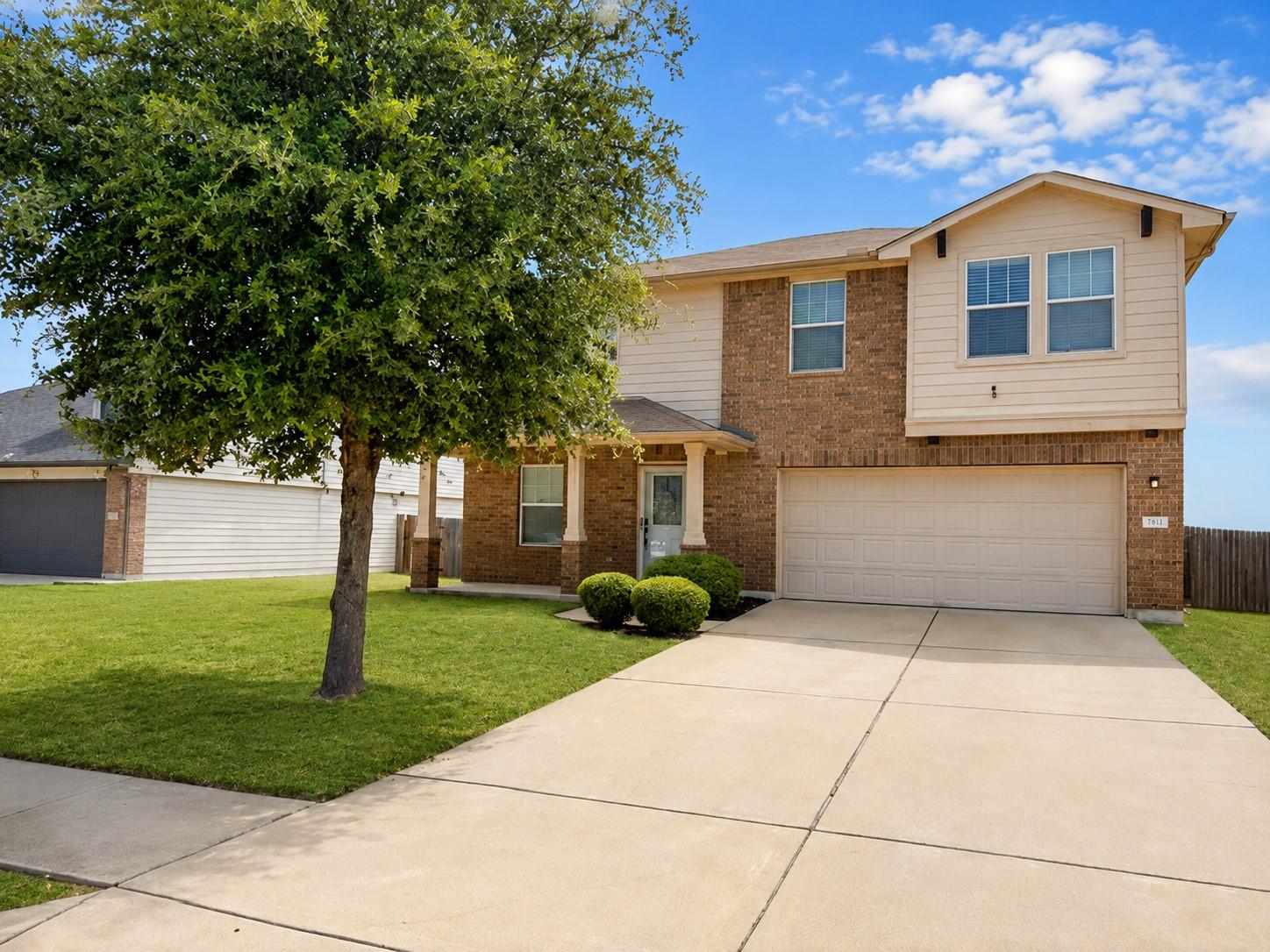 A classic brick and siding home presents a welcom