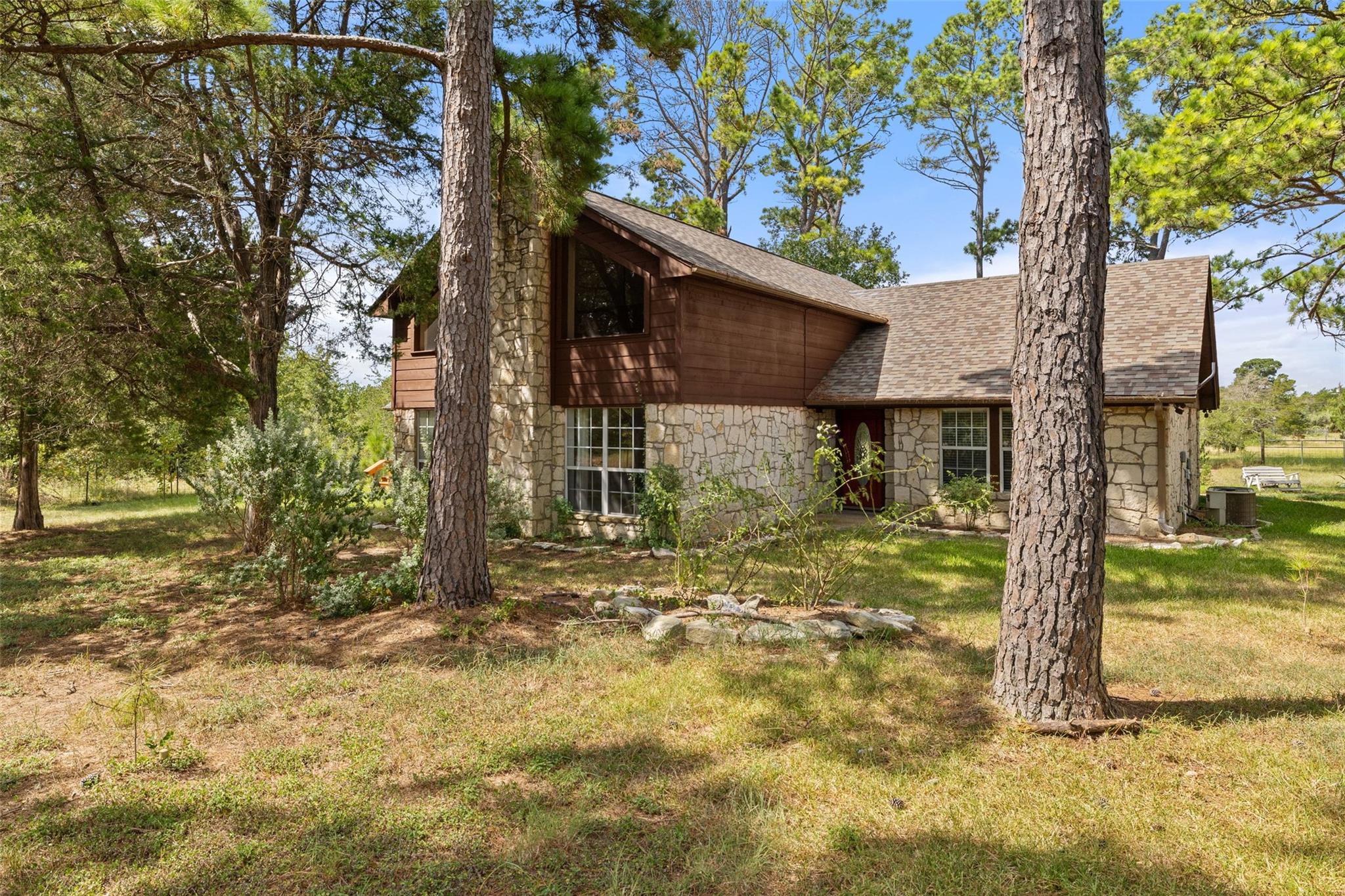 A rustic facade, framed by mature trees, showcase