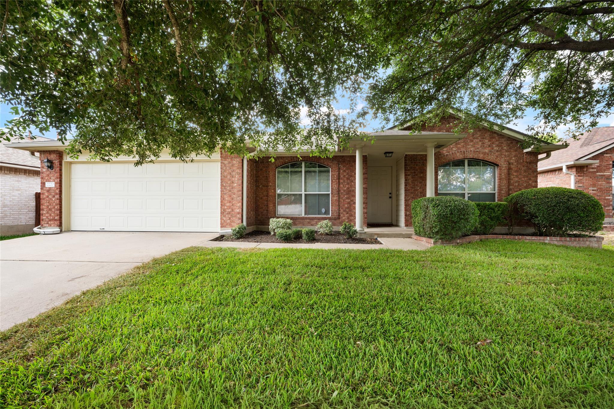 Mature trees shade the classic brick exterior of 