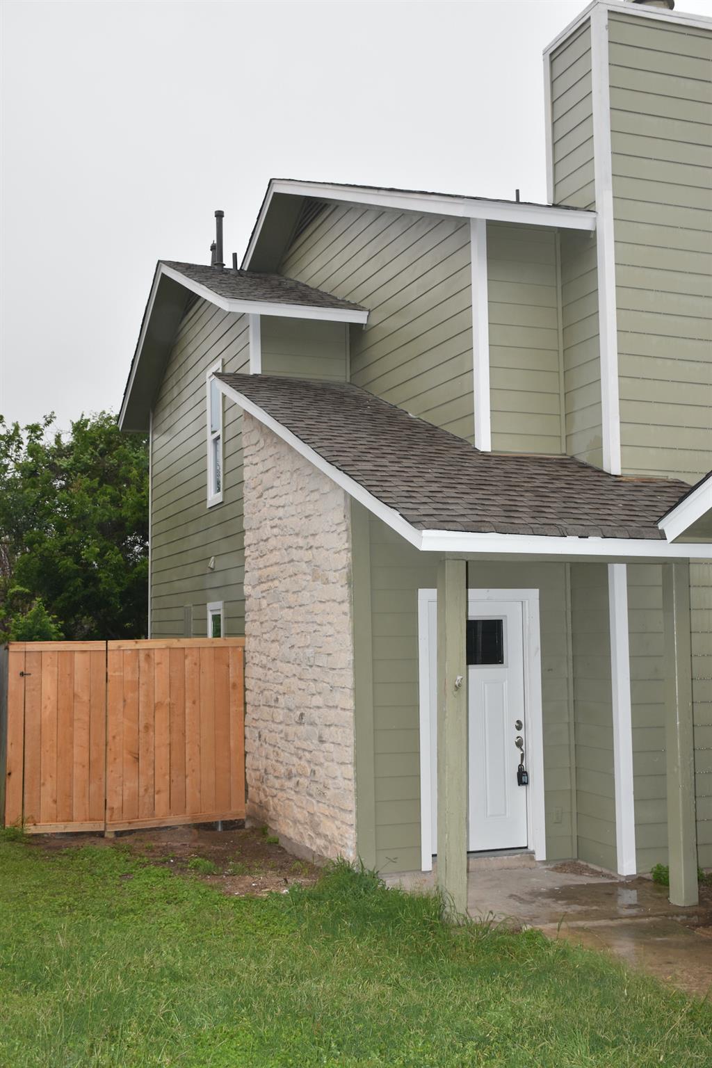 A welcoming entry featuring a covered porch, ston