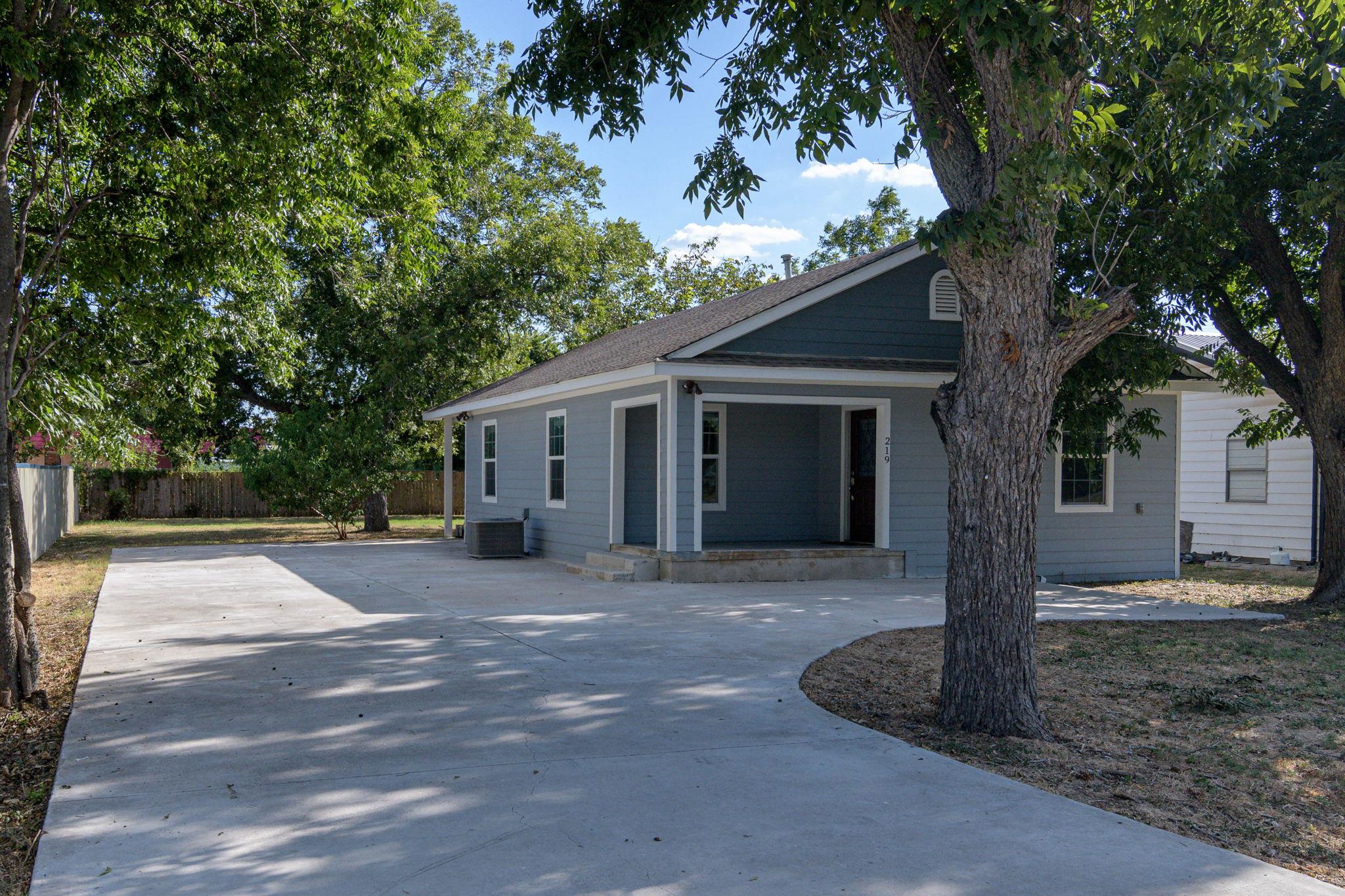 A well-maintained concrete driveway leads to a ch