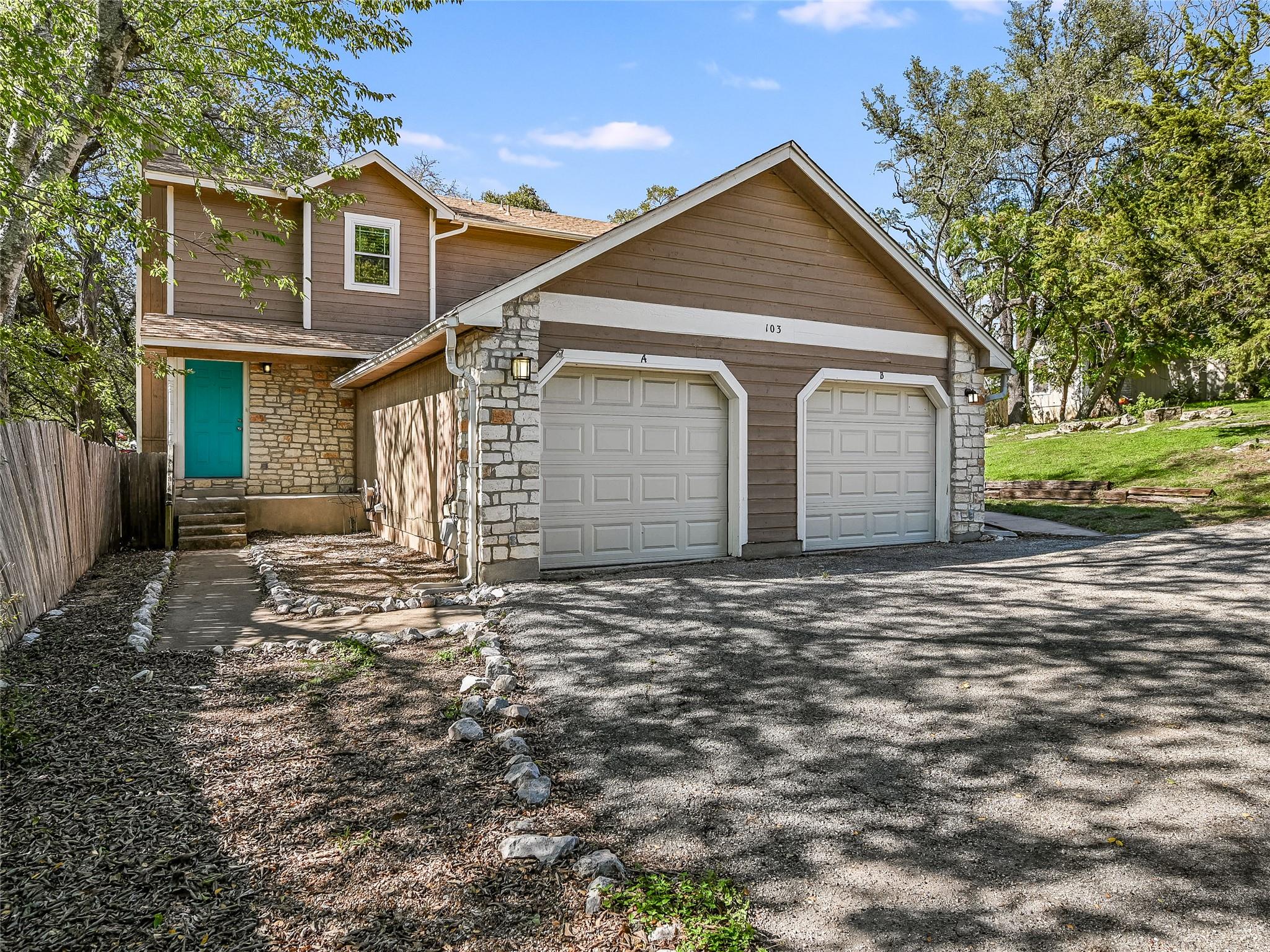 Two-car garage with overhead doors and a stone an