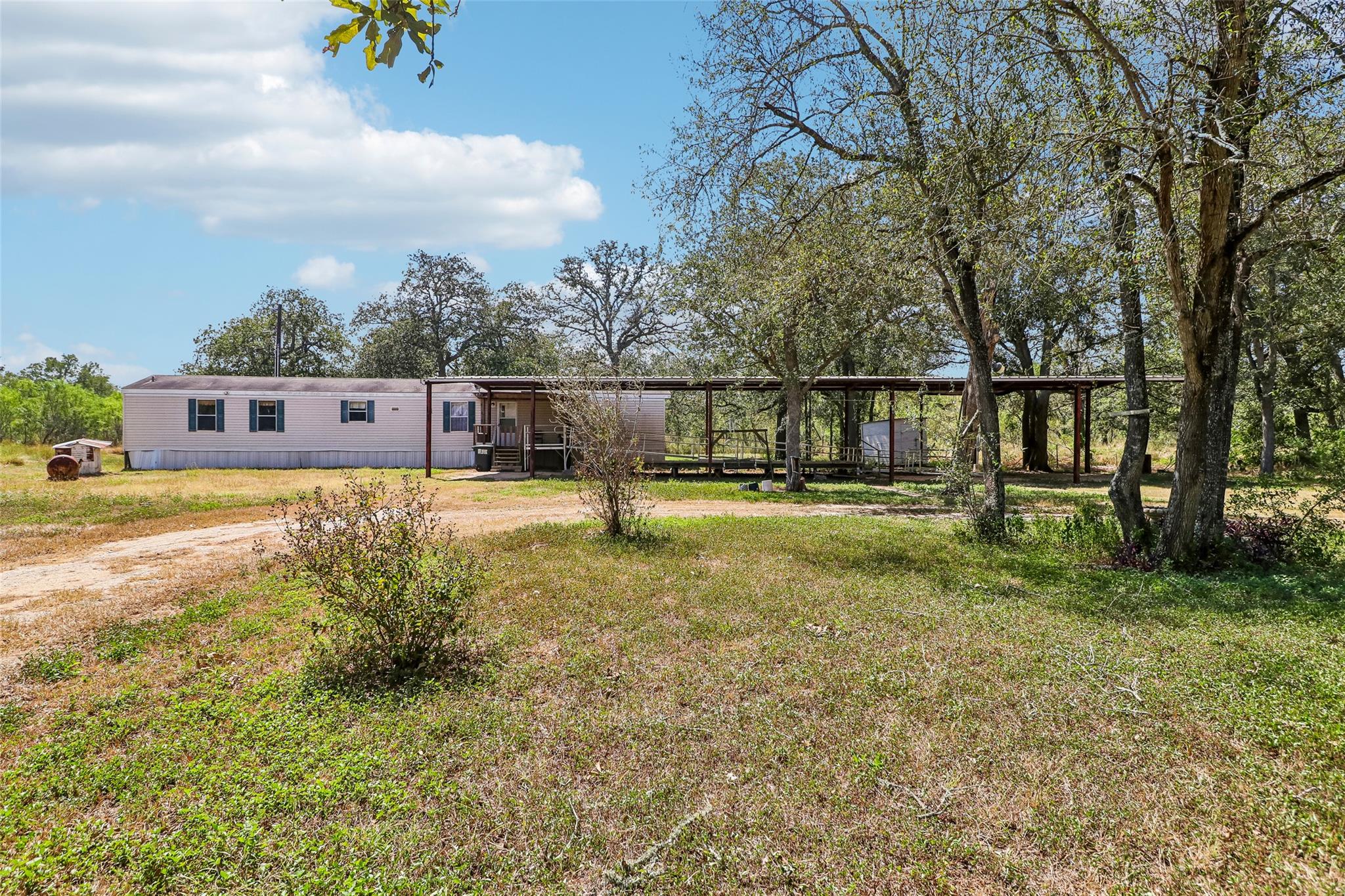Mature trees shade the expansive grassy acreage s