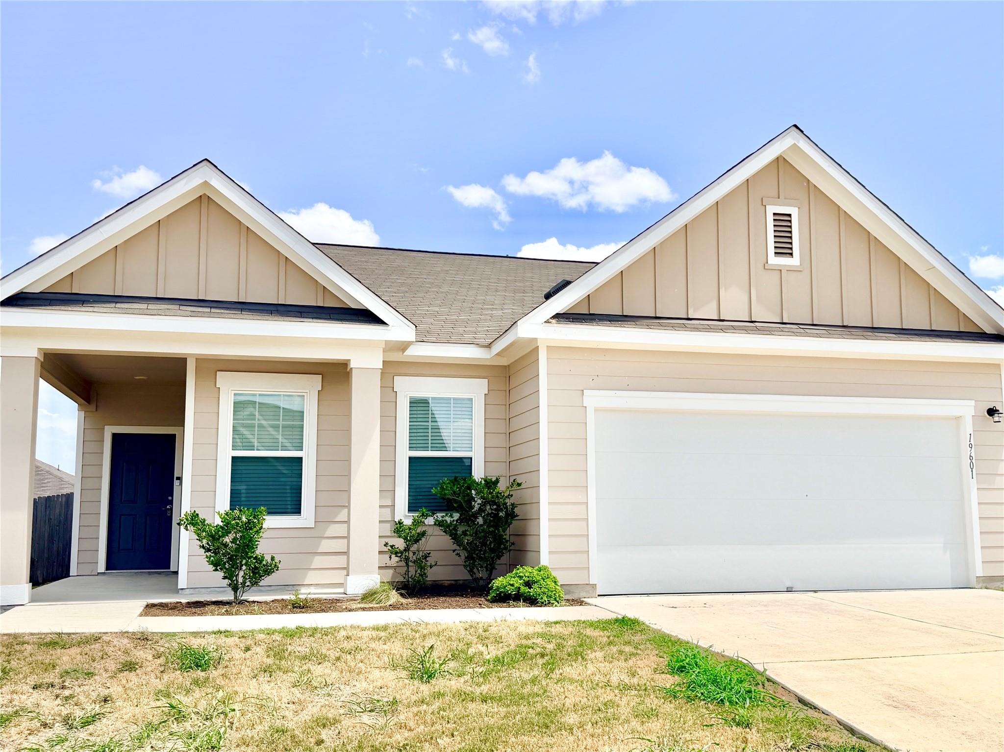 A welcoming facade showcases a broad garage door 