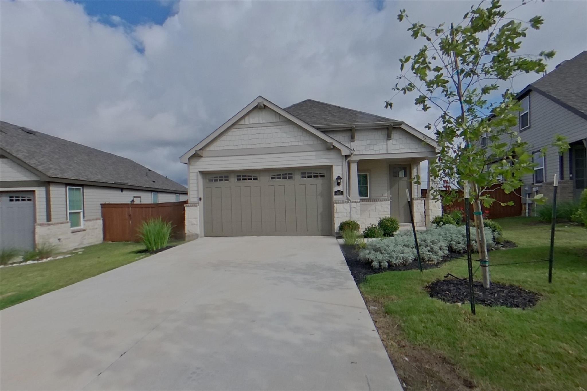 A welcoming facade showcases a broad driveway lea