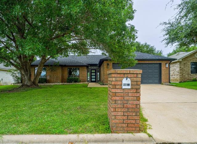 Mature trees shade a classic brick exterior compl