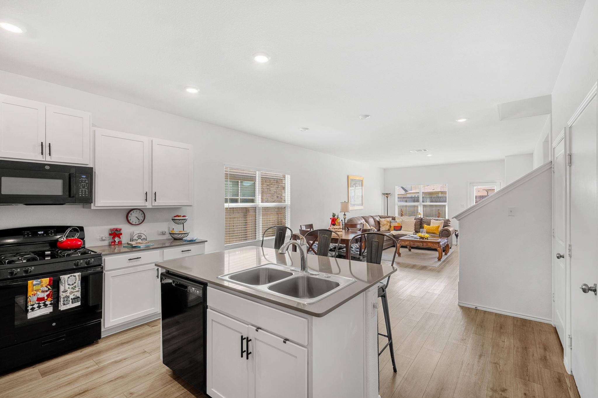 A well-lit kitchen with modern white cabinetry fl