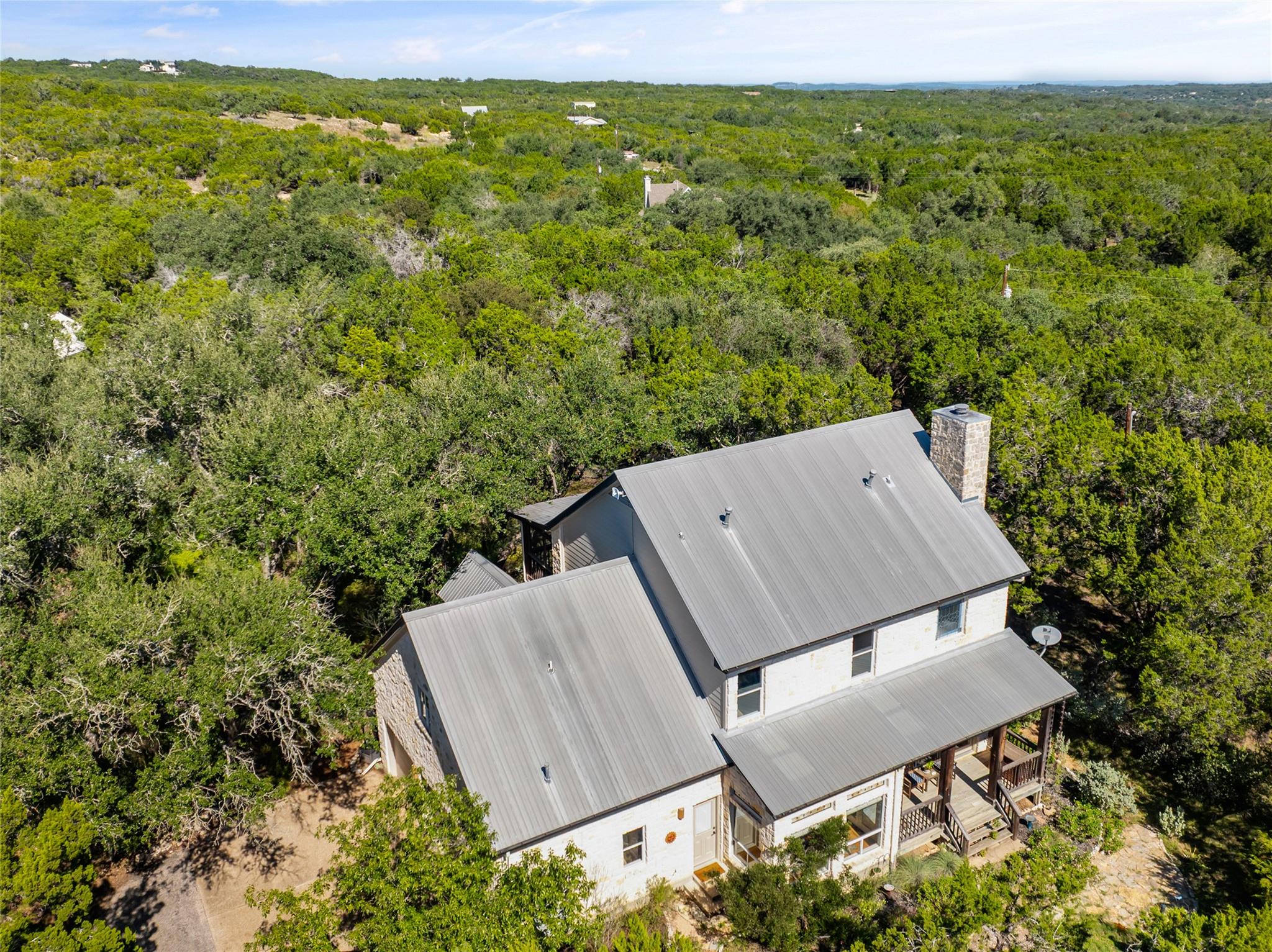A metal roof and stone chimney complement this ho