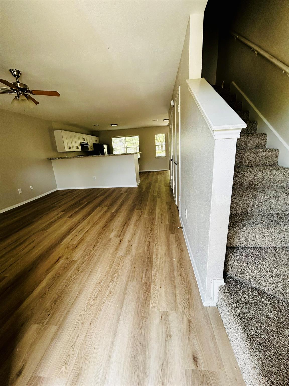 An open-concept living area features a wood-look 