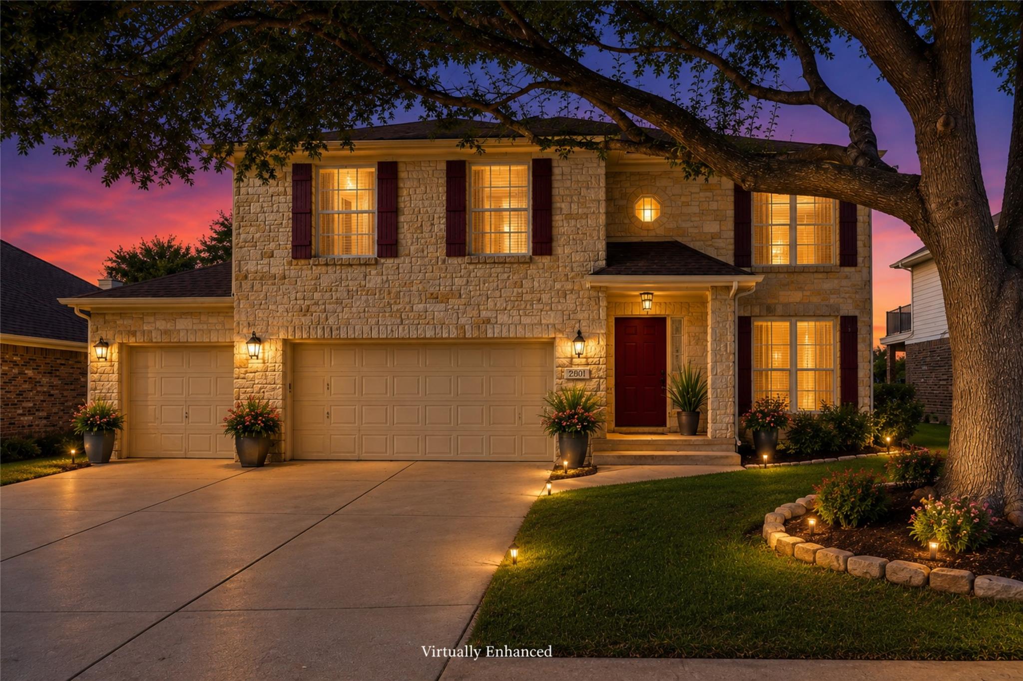 Textured stone siding and a wide concrete drivewa