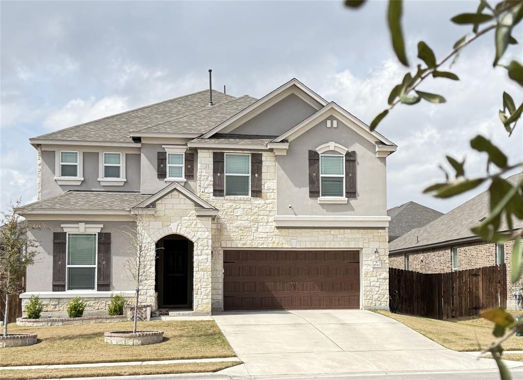 A well-maintained two-story residence with a ston