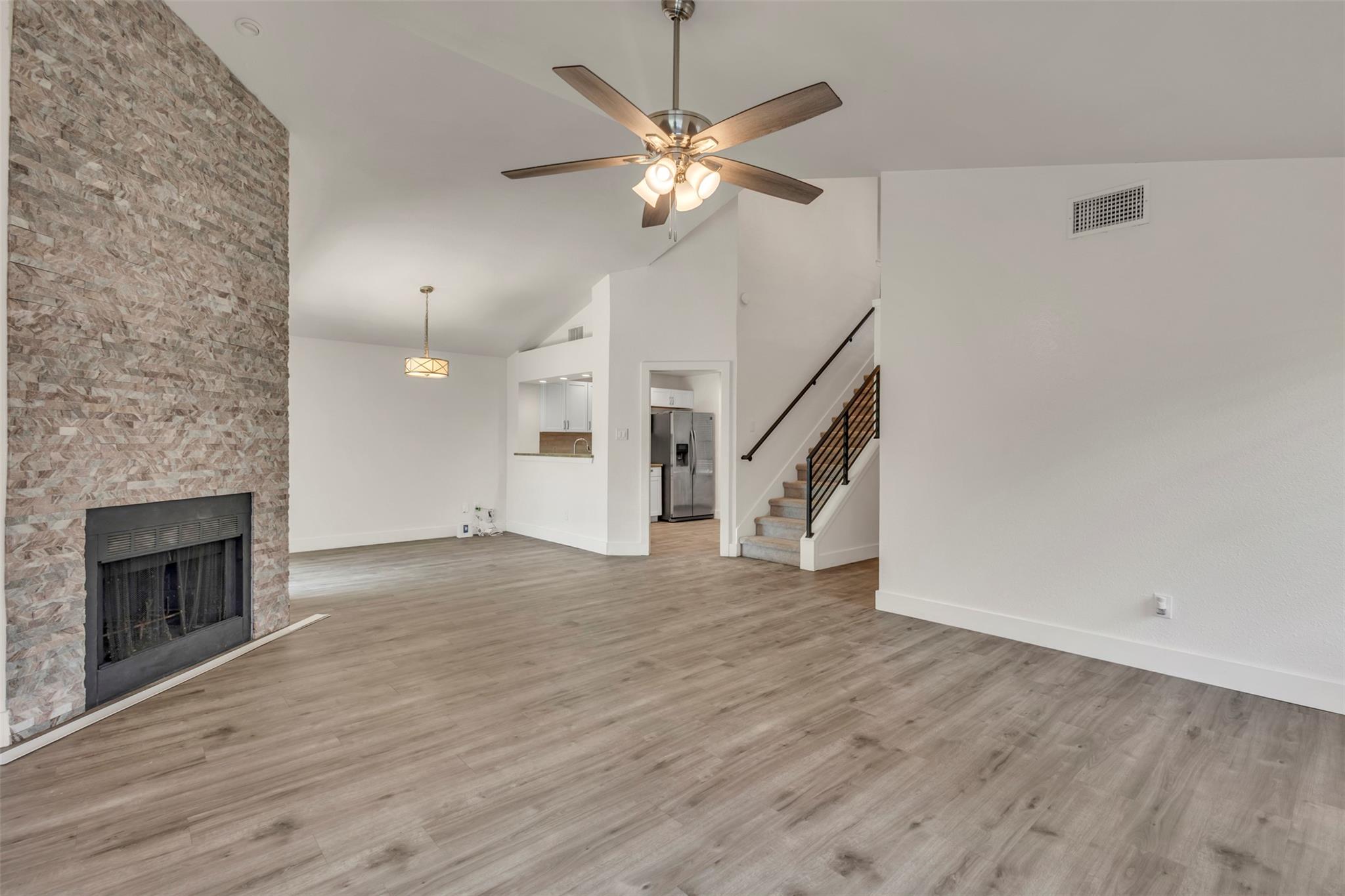 A spacious living area features a stone fireplace