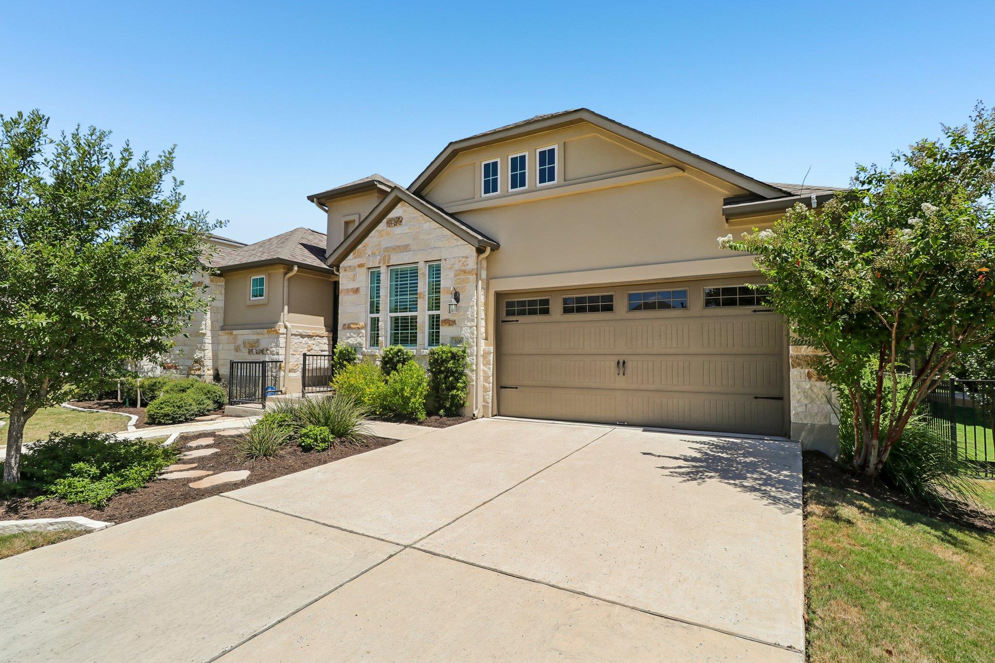 A spacious concrete driveway leads to an elegant 