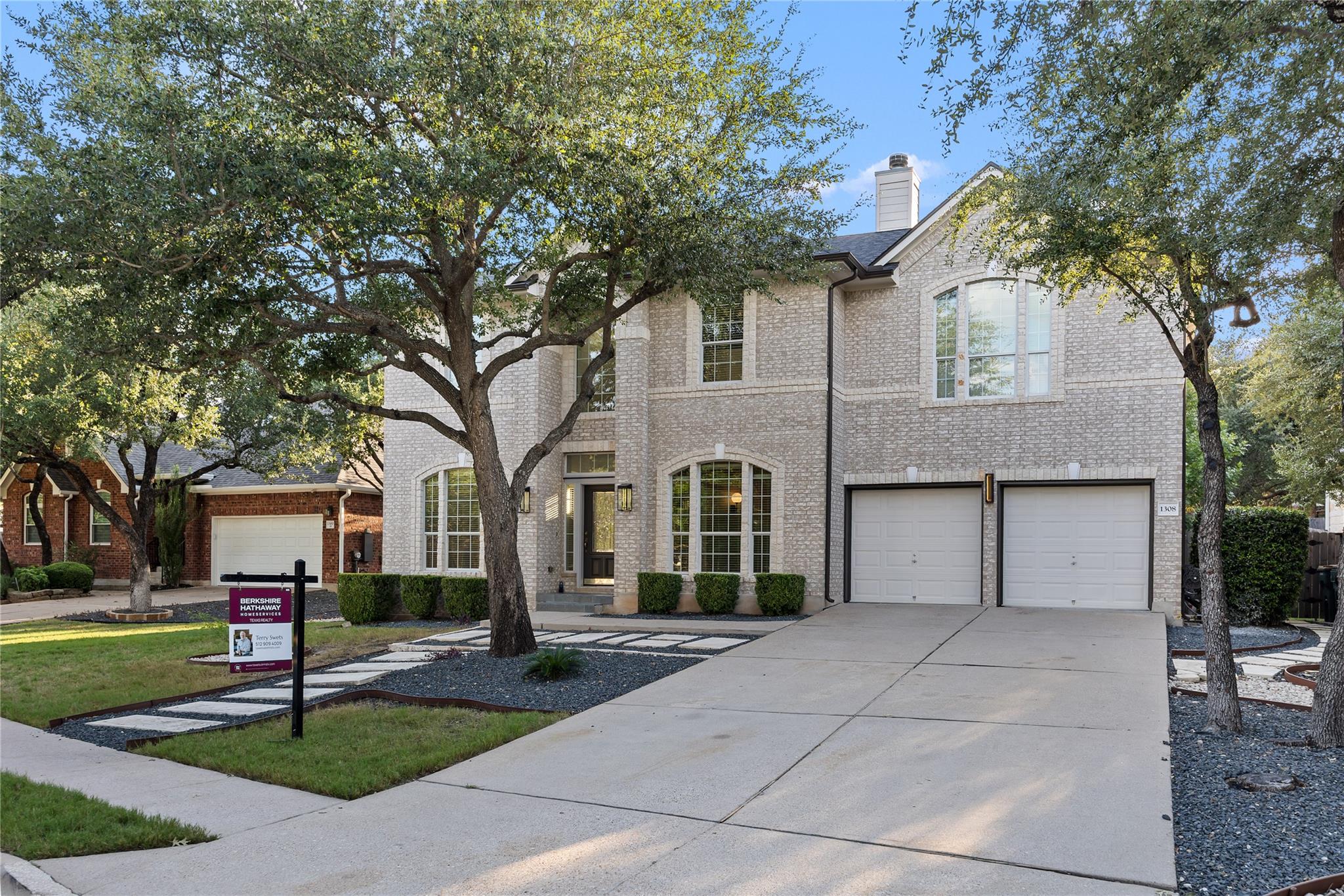 Mature trees shade a classic brick exterior with 