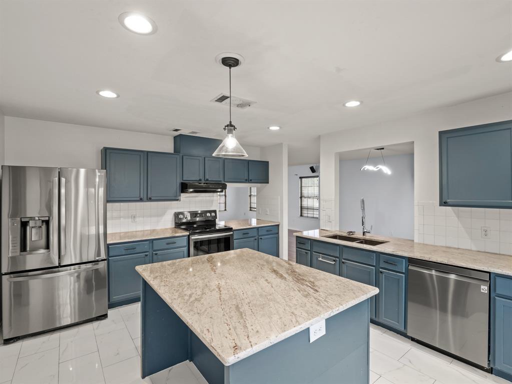 A well-appointed kitchen features a central islan