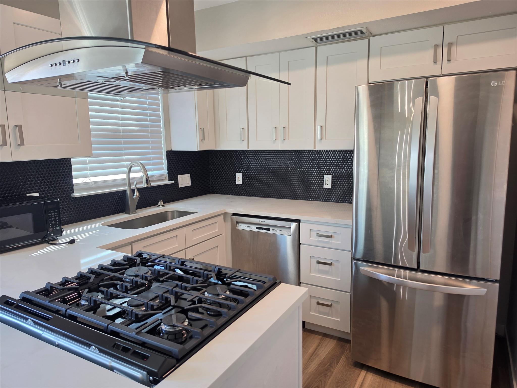 A contemporary kitchen features stainless steel a