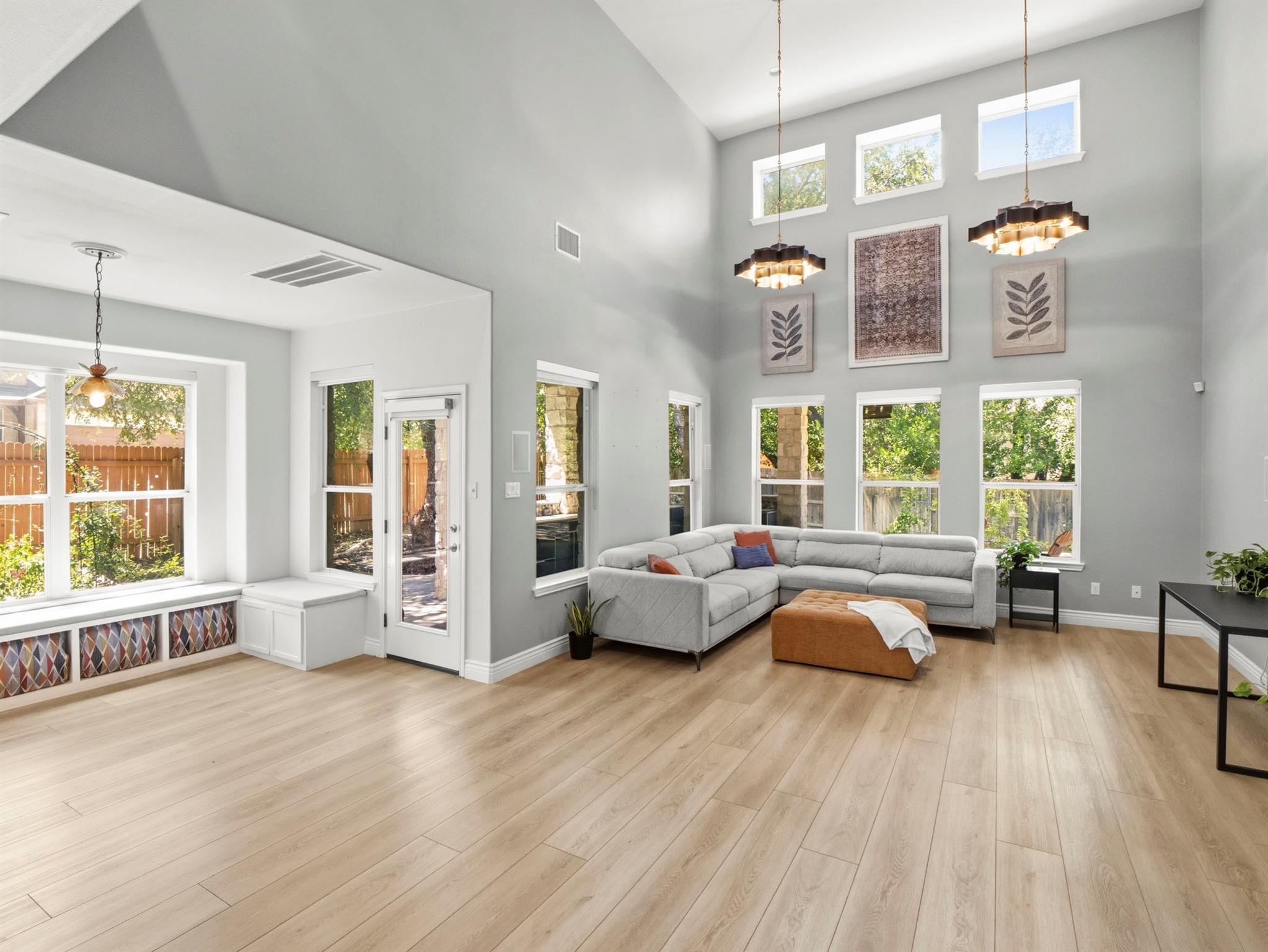 A spacious living area with tall windows and ligh