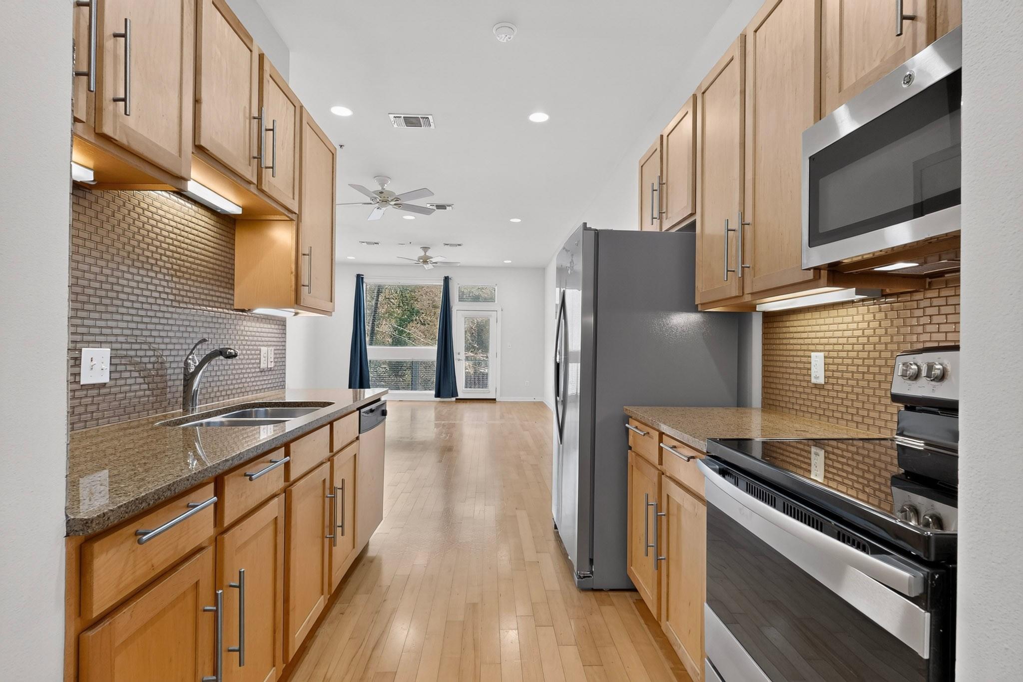 Warm wood cabinetry and granite countertops frame