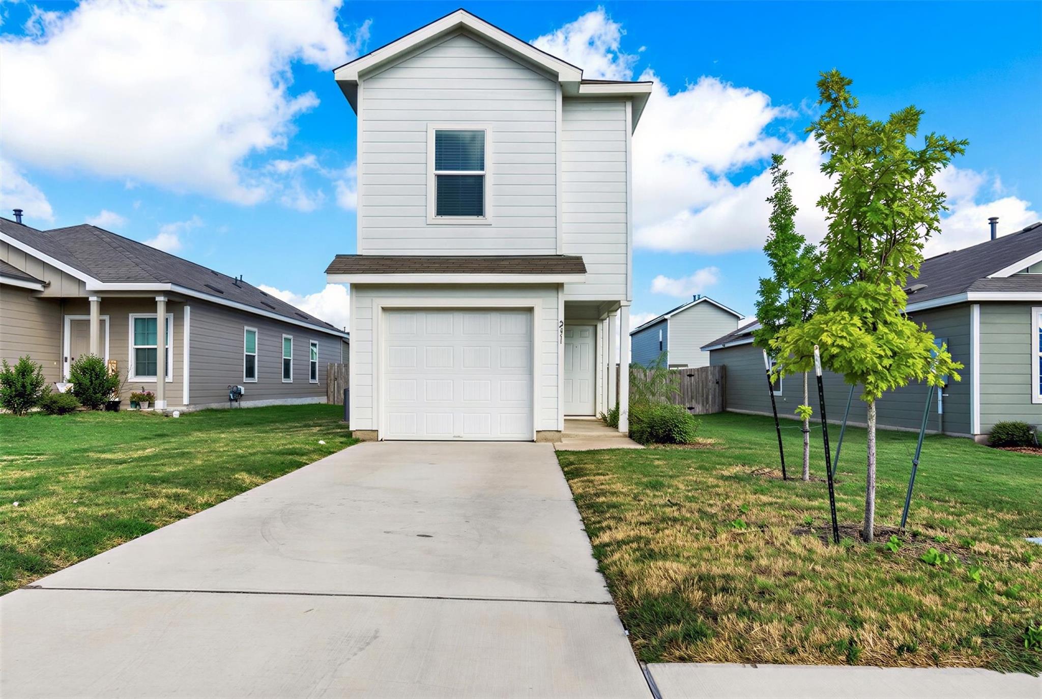 A concrete driveway leads to the attached garage 