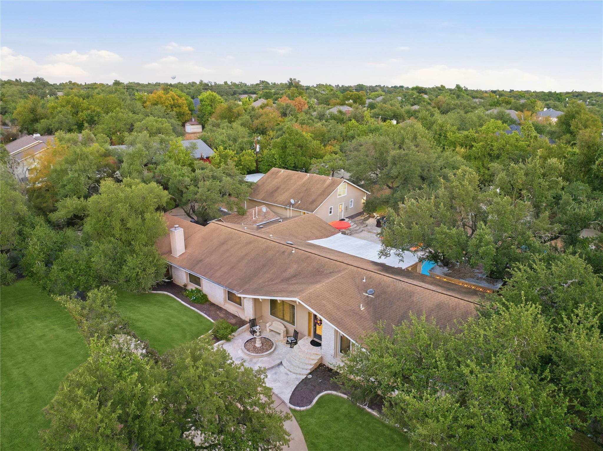 Mature trees surround this sprawling single-story