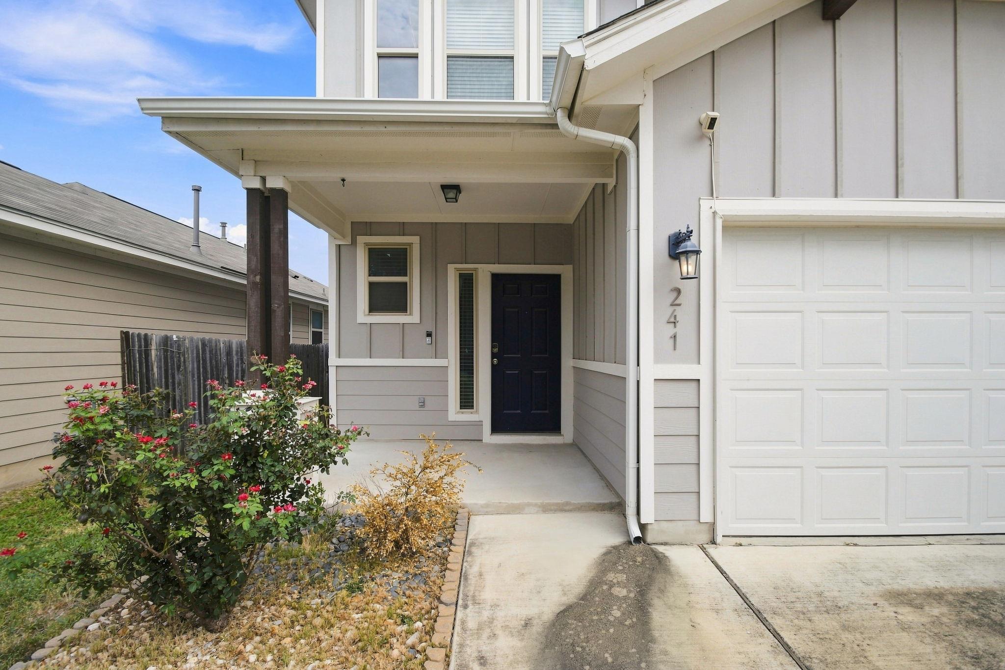 A welcoming front porch leads to the dark entry d
