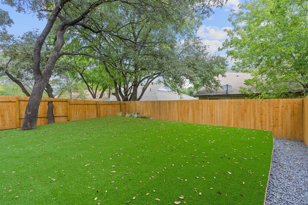 Mature shade trees canopy a level yard enclosed b