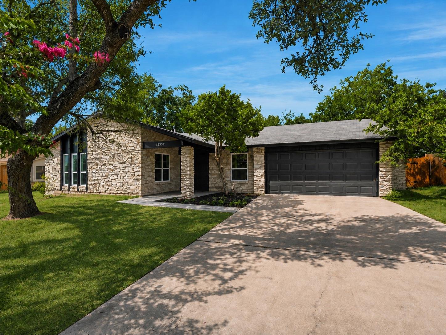 Mature trees shade a classic stone exterior accen