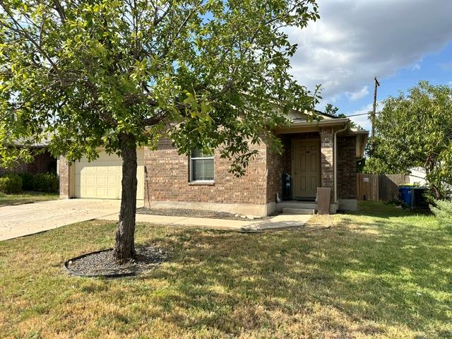 Mature trees shade the brick exterior and concret