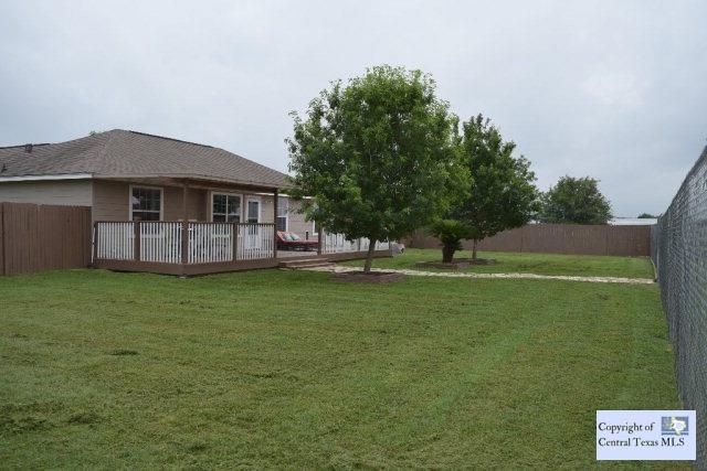 A spacious grassy lawn borders the home with an e