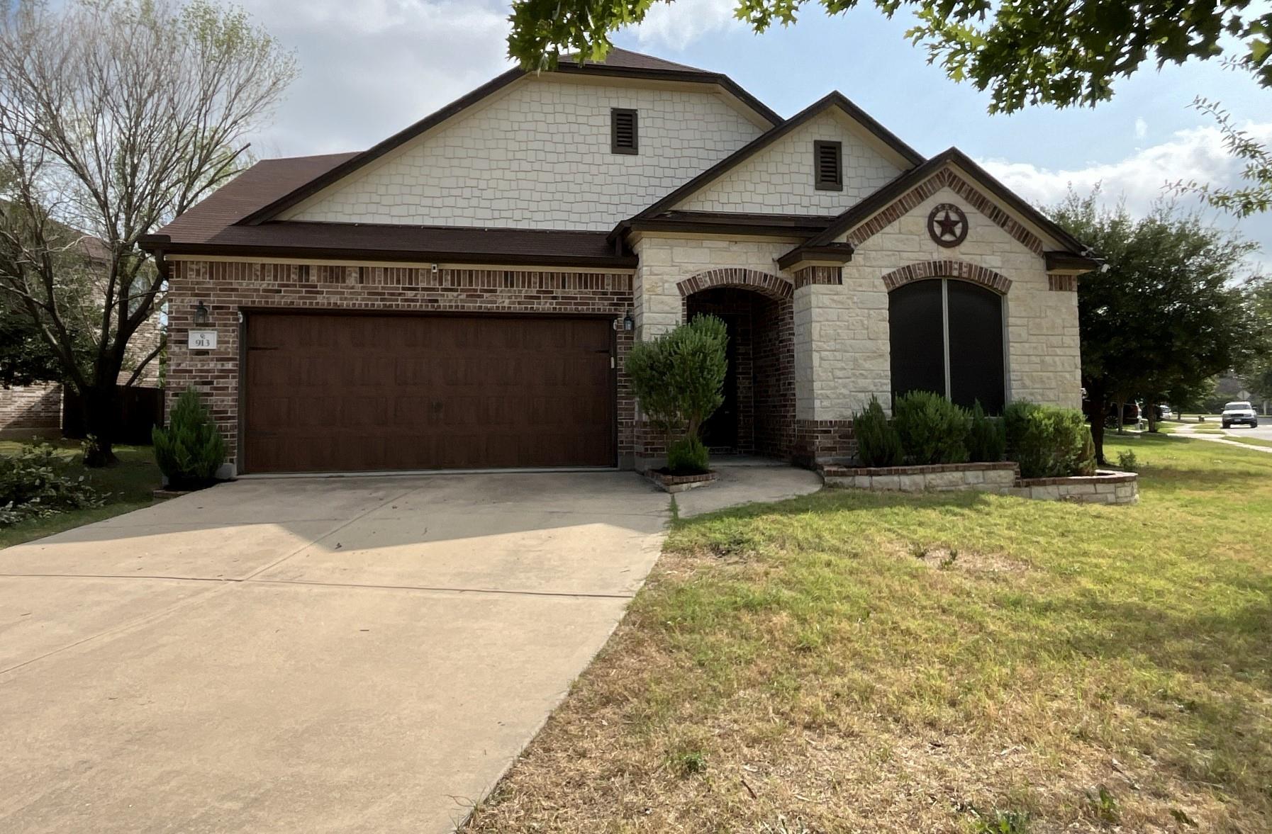 Multi-textured masonry and a wide concrete drivew