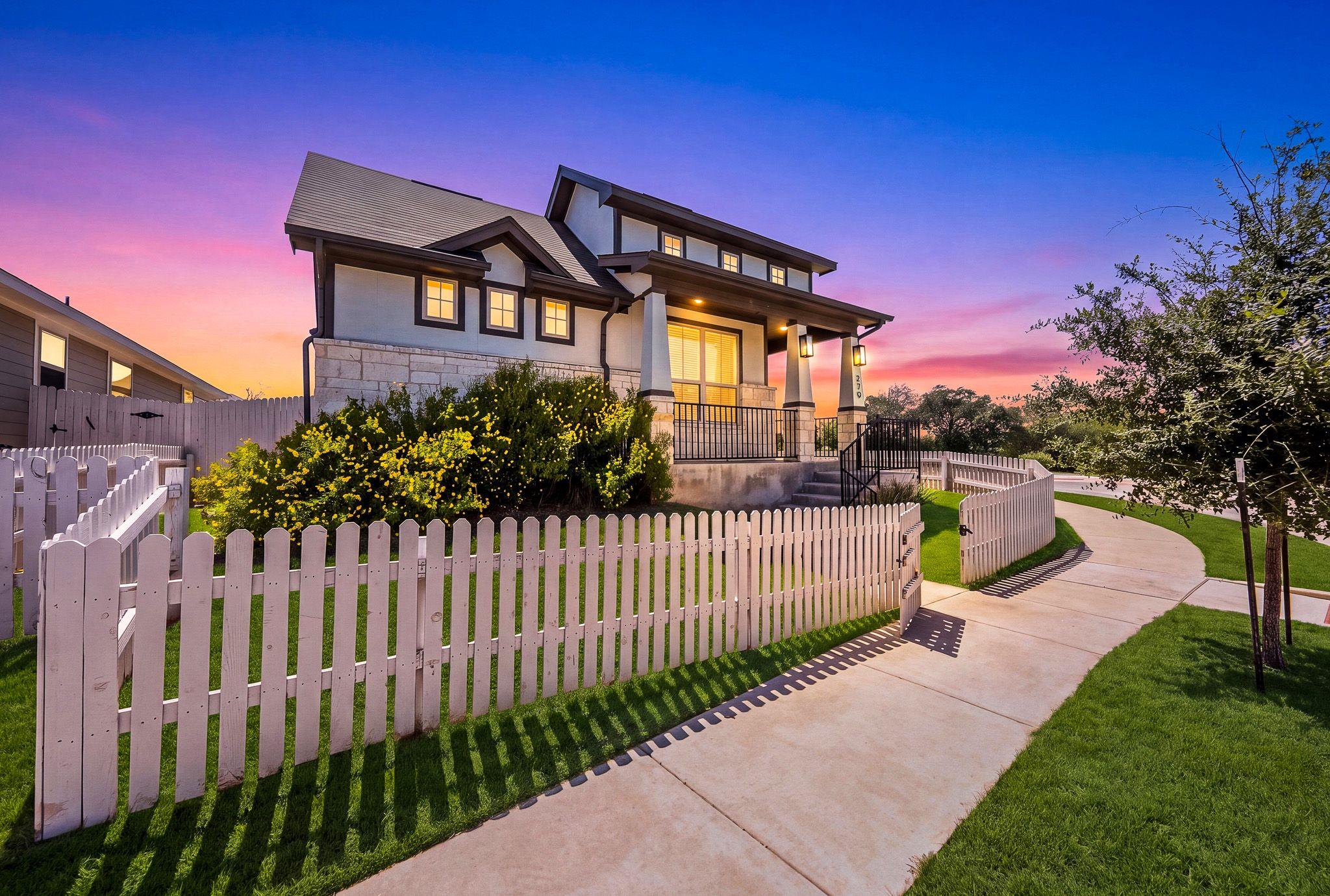 A curved concrete sidewalk leads past a classic p