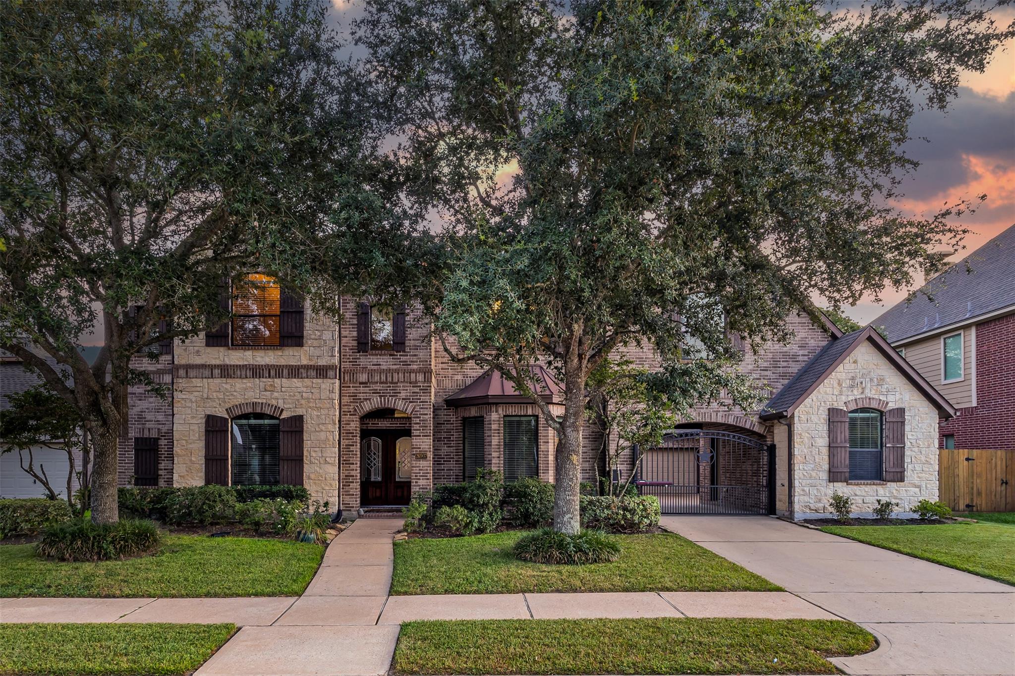 Mature trees shade a stately brick and stone exte
