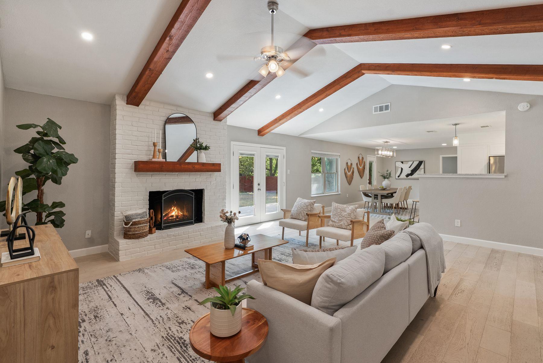 Exposed wood beams and a brick fireplace define t