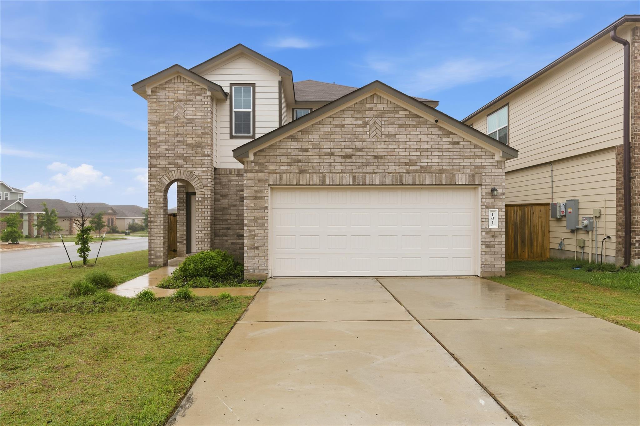Brick accents and a clean concrete driveway creat